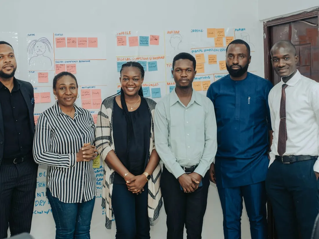 Members of the Bragi team in front of a wall of user-persona and behavior research notes.