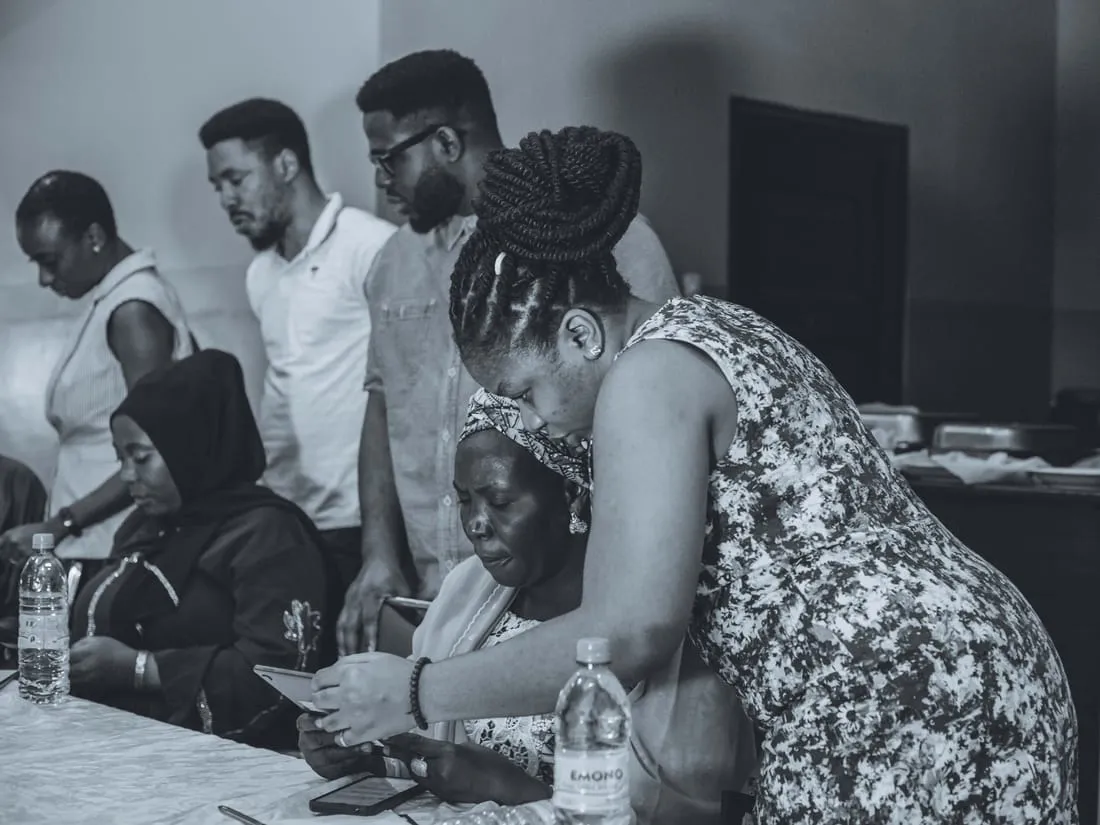 Colleagues gathered around a laptop during a working session (black and white).
