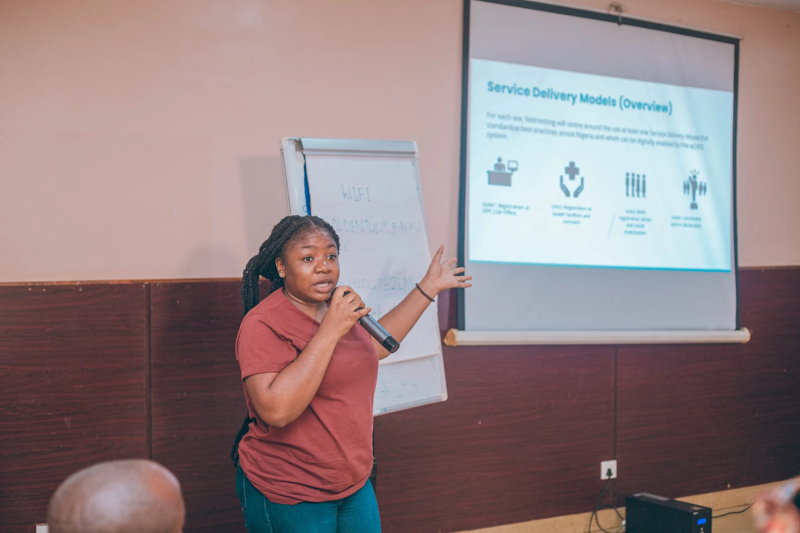 A Bragi facilitator presenting a “Service Delivery Models” slide to participants during a field-testing workshop.